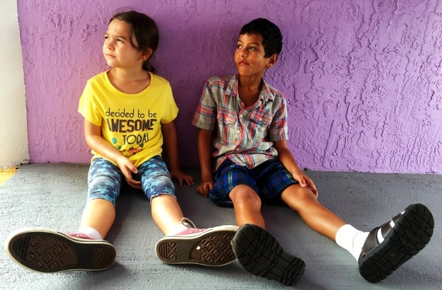 The Florida Project (Szenenbild: Moonee und ihr Freund sitzen auf dem Boden. Die Hauswand ist  violett.) © PROKINO Filmverleih GmbH)
