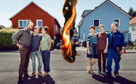 Deutscher, Imagebild: Die Familie Schneider (links) steht vor ihrem roten Haus, die Familie Pielke vor ihrem blauen Haus. Dazwischen symbolsiert eine Flamme den Zwist der Nachbarn. (© ZDF/Martin Rottenkolber) 