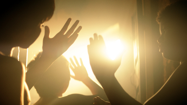 Das Licht, aus dem die Träume sind, Szenenbild: Kinder, im Gegenlicht aufgenommen, halten ihre Hände ins Licht. (© Neue Visionen)