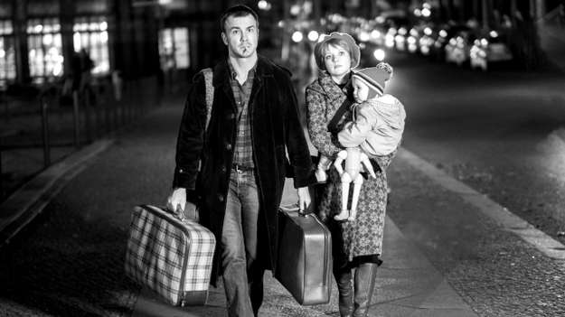Lieber Thomas, Szenenbild: Ein Mann und eine Frau gehen nachts durch Berlin. Er trägt einen Koffer, sie ein Kind im Arm. Sie schauen ernst. (© Zeitsprung Pictures / Wild Bunch Germany (Foto: Peter Hartwig))