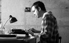 Lieber Thomas, Szenenbild: Ein junger Mann sitzt an einem Tisch und tippt auf der Schreibmaschine. Er hat eine Zugarette im Mund. (© Zeitsprung Pictures / Wild Bunch Germany (Foto: Peter Hartwig))