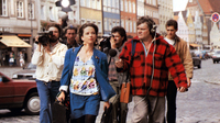 Das schreckliche Mädchen, Szenenbild: Eine Gruppe von Reportern folgt einer Frau durch die belebte Straße einer Altstadt (© IFTN / picture alliance / United Archives)