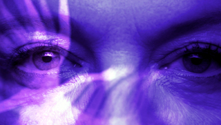 Brainwashed - Sexismus im Kino, Szenenbild: Frontale Nahaufnahme eines Augenpaars. Das Bild ist in Blau getaucht. Auf den Augen und ihrem Umfeld liegt eine helle Reflektion (© 2022 brainwashedmovie LLC)