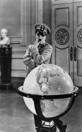Der große Diktator, Szenenbild: Ein schnauzbärtiger Mann steht mit verschränkten Armen hinter einem Globus und schaut nachdenklich auf die Erdkugel (© picture-alliance/dpa, dpa)