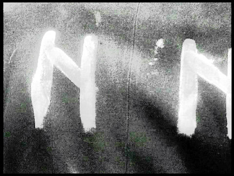 Nacht und Nebel, Filmstill in Schwarz-Weiß: Detailaufnahme des Schriftzugs N N, der auf dem Rücken einer Jacke mit weißer Farbe gemalt wurde
