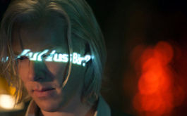 Inside Wikileaks - Die fünfte Gewalt, Szenenbild: Nahaufnahme eines blonden Mannes. Auf seinem Gesicht reflektiert ein Schriftzug  (© Constantin Film)
