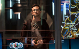 Snowden, Szenenbild: Halbnahe Einstellung eines Mannes, der hinter einer Glaswand steht. (© Universum Film)