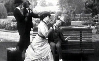 Die Folgen des Feminismus, Screenshot aus dem Kurzfilm: Eine Frau sitzt neben einem Mann auf der Bank und belästigt ihn. (© Alice Guy, Frankreich 1906, Quelle: https://archive.org/details/silent-les-rsultats-du-fminisme-aka-the-consequences-of-feminism, gemeinfrei)
