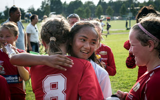 Kids Cup, Szenenbild: Zwei Mädchen im Fußballtrikot umarmen sich. (© Eirik Linder Aspelund /ARD)