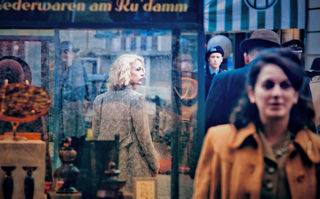 Stella. Ein Leben, Szenenbild: Eine blonde Frau steht am Berliner KuDamm und schaut sich um. Passant/-innen laufen an ihr vorbei. (© Christian Schulz &amp; Majestic Filmverleih)