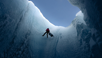Into the Ice, Szenenbild: Totale eines Mannes, der sich an einem Seil in eine Gletscherspalte herablässt (© Lars Henrik Ostenfeld)
 