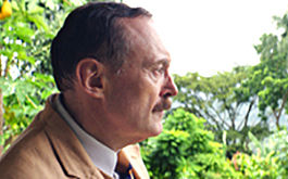 Vor der Morgenröte, Szenenbild: Stefan Zweig, gespielt von Josef Hader, im Profil am linken Bildrand. Er steht vor einer Dschungellandschaft. (© X Verleih)