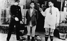 Laurel &amp; Hardy: Der beleidigte Bläser, Szenenbild: Laurel und Hardy stehen in Unterhosen neben einem Polizisten (© Picture Alliance Mary Evans Picture Library)