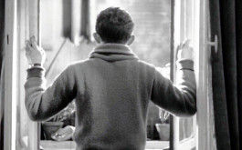 Kuhle Wampe, Filmstill: Rückenansicht eines jungen Mannes, der an einem geöffneten Fenster steht. (© Praesens Film)