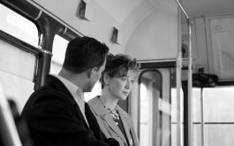 Belfast, Szenenbild: Ein Mann und eine Frau sitzen im Obergeschoss eines Buses und sprechen miteinander. (© Rob Youngson / 2021 Focus Features, LLC.)