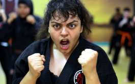 Nico, Szenenbild: Nahaufnahme einer Frau beim Karate-Training. Sie hält ihre Fäuste erhoben und schreit. (© Darling Berlin / UCM.ONE)