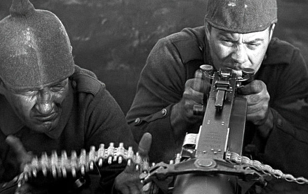 Im Westen nicht Neues (1930), Szenenbild: Zwei Soldaten bedienen in einer halbnahen Einstellung ein Maschinengewehr (© Capelight Pictures/Universal)