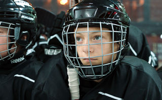 Close, Szenenbild: Nahaufnahme eines Jungen, der einen Eishockey-Helm mit Gitterschutz trägt. (© Pandora Film)