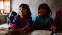 Lunana – Das Glück liegt im Himalaya, Szenenbild: Naufnahme von zwei Schulmädchen, die in an einem Schultisch sitzen (© Kairos Filmverleih)