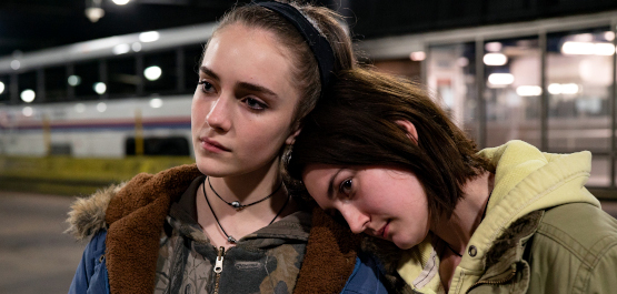 Niemals Selten Manchmal Immer, Filmszene: Nahaufnahme: Zwei Mädchen im Teenageralter stehen in einer U-Bahn-Station. Dsa eine legt ihren Kopf auf die Schulters des anderen. (© 2020 Focus Features, LLC. All Rights Reserved)