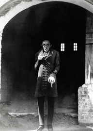 Nosferatu - Eine Symphonie des Grauens, Szenenfoto: Ein unheimlicher Mann steht in einem Torbogen (© picture alliance / United Archives / IFTN)