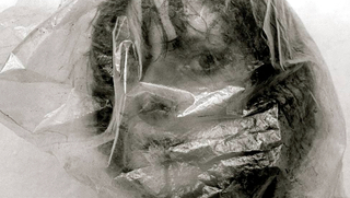 Rebellinnen – Fotografie. Underground. DDR, Szenenbild: Schwarz-Weiß-Foto einer Frau, deren Kopf in einer durchsichtigen  Plastiktüte steckt (© Bernd Hiepe / Salzgeber)