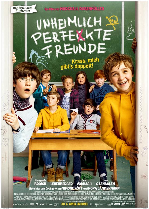 Plakat zum Kinderfilm UNHEIMLICH PERFEKTE FREUNDE: Zwei Jungen im Grundschulalter stehen an einem Türrahmen und schauen in Richtung des Betrachtenden. Ein Junge lacht, der andere sieht eher erschrocken aus. Im Hintergrund sitzen Kinder, auf einer Tafel steht der Flmtitel.