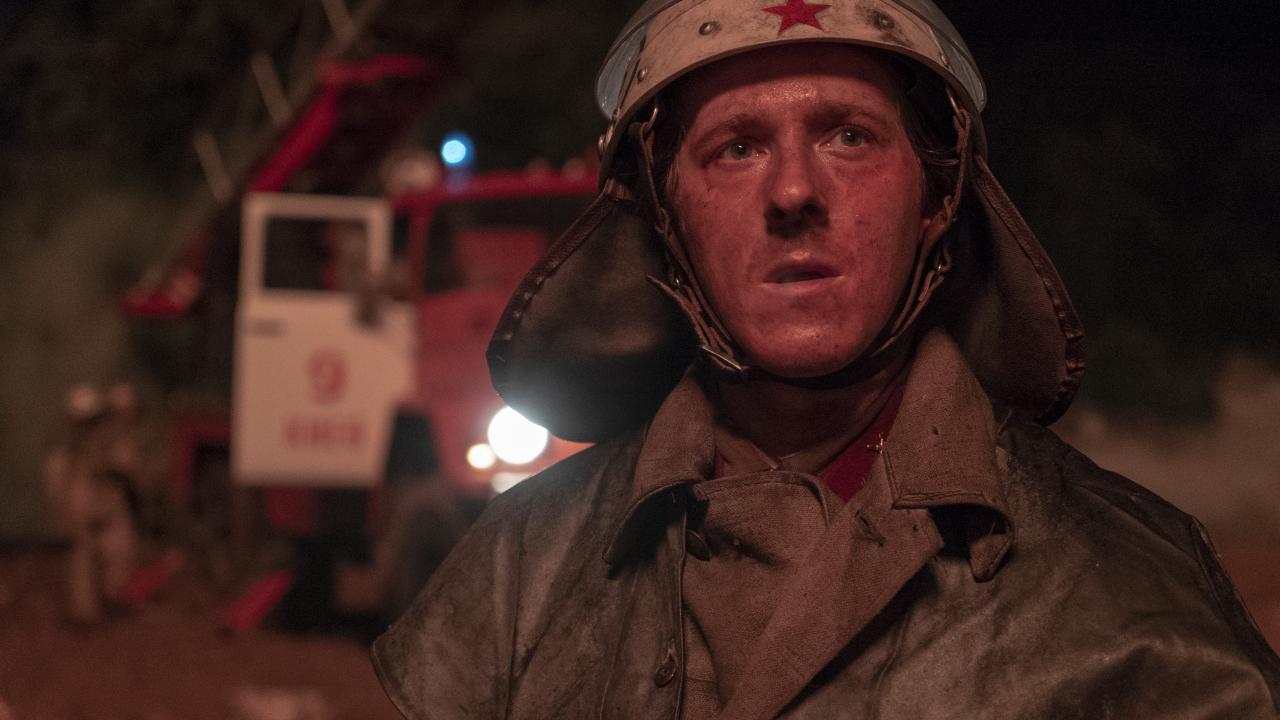 Nahaufnahme eines Feuermannes im Einsatz, der den Betrachtenden anschaut