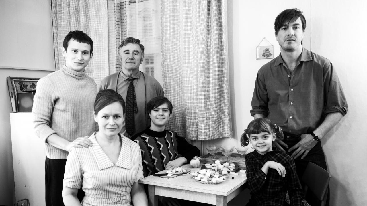 Szenenbild aus dem Drama "Lieber Thomas": Eine fünfköpfige Familie posiert an einem Tisch.