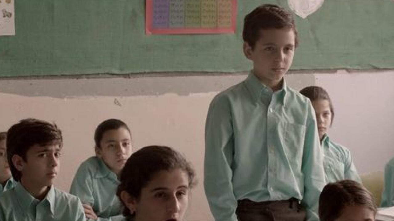 Mein Herz tanzt, Szenenbild: ein Junge steht im grünen Schulhemd in einer Klasse. Alle um ihn rum sitzen. 