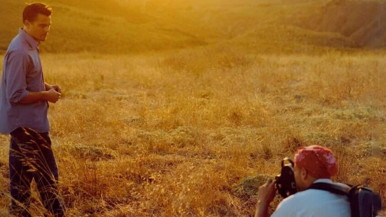 11th Hour - 5 vor 12, Szenenbild: Ein Mann steht in einem gelben Feld während eine andere Figur ihn filmt