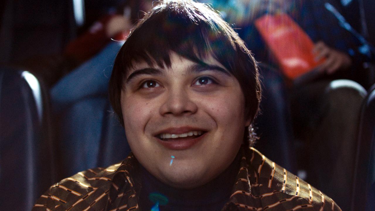 Still aus dem Drama I LIKE MOVIES: Großaufnahme eines jungen Mannes, der im Kino sitzt