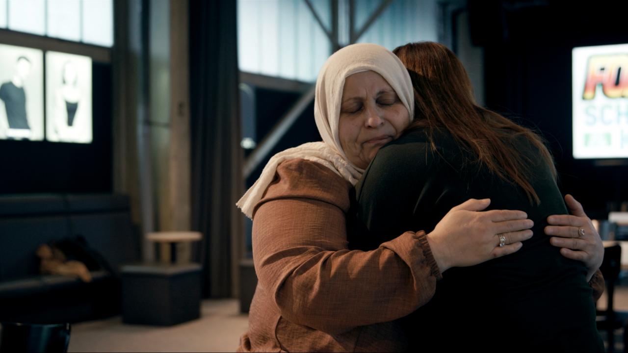 Still aus dem Dokumentarfilm DIE MÖLLNER BRIEFE: Mutter Arslan umarmt eine Mitarbeiterin von DOMiD.