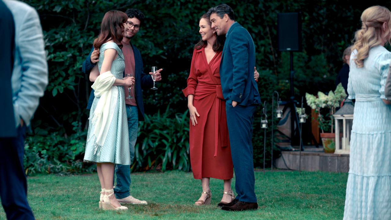 Filmstill aus dem Drama THE CHANGE: In einem Garten stehen sich zwei gut angezogene Paare unterscheidlichen Alters gegenüber und sprechen miteinander.