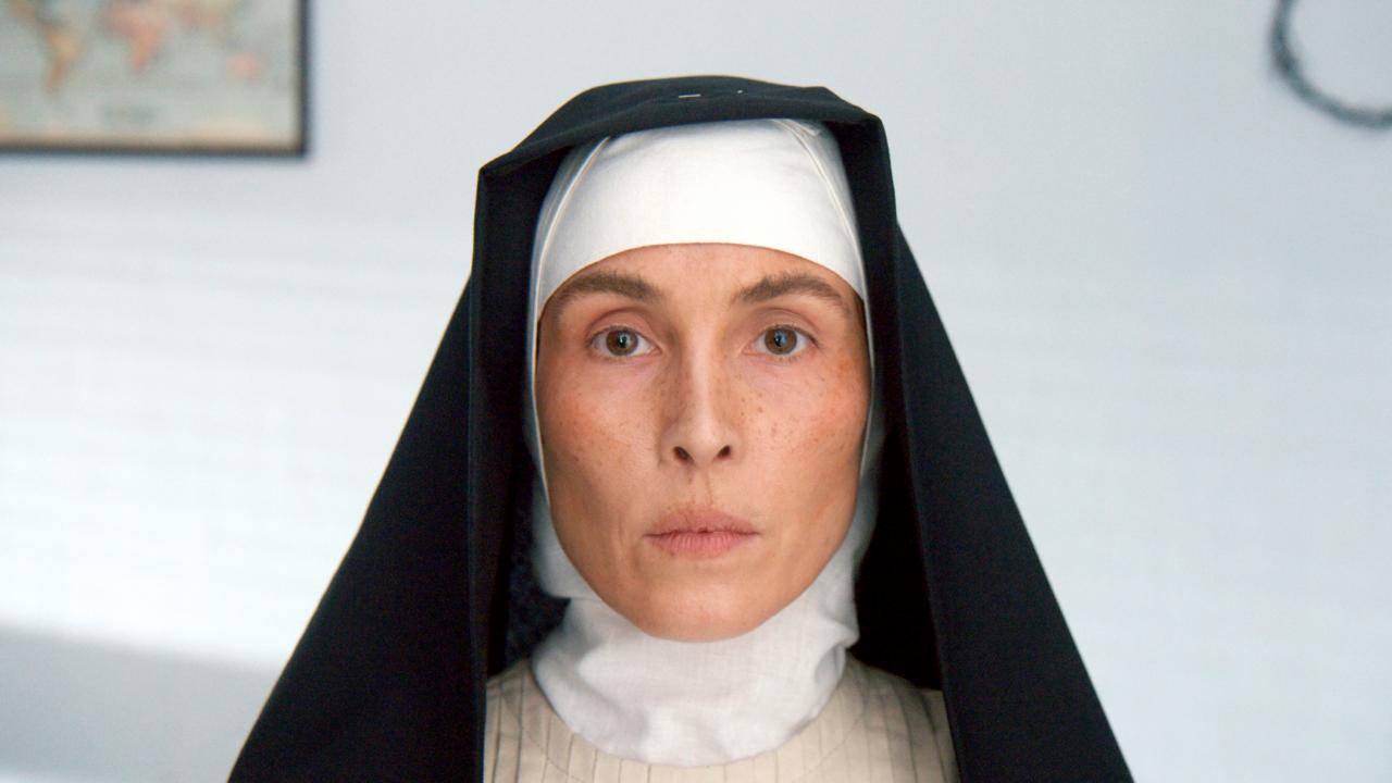Filmstill aus dem Drama und Biopic TERESA – LEBEN ZWISCHEN LICHT UND SCHATTEN: Eine junge Frau – es soll Mutter Teresa sein – schaut in Ordenstracht direkt in die Kamera.