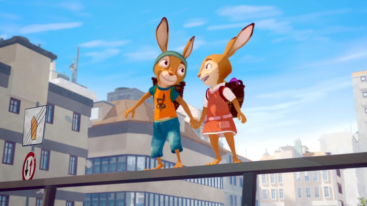 Still aus dem Animationsfilm DIE HÄSCHENSCHULE – JAGD NACH DEM GOLDENEN EI: Zwei junge Häschen stehen auf einen Geländebalken und halten Händchen. Der Linke Hase trägt eine blaue Mütze, ein orangenes T-shirt und Jeans. Der rechte Hase trägt ein rosanes Kleid und ein Rucksack. Im Hintergrund sind Stadtgebäude und der blaue Himmel. 
