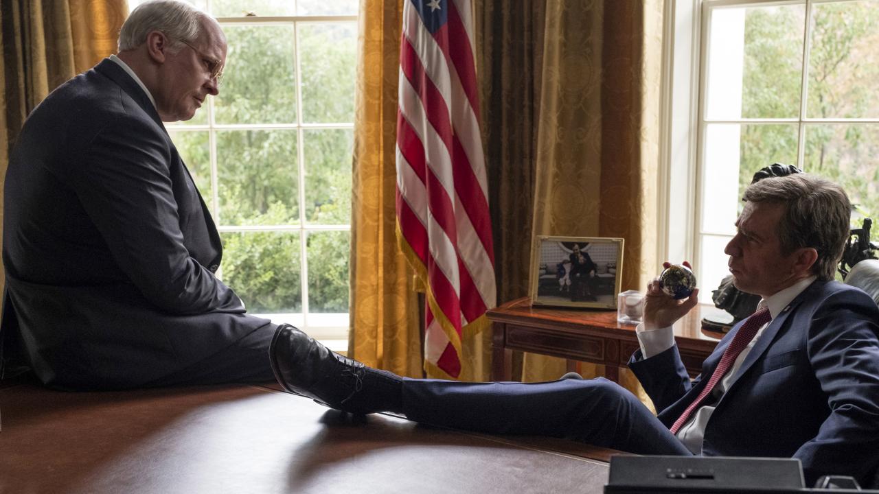 Still aus dem Biopic VICE – DER ZWEITE MANN: Christian Bale und Sam Rockwell in den Rollen von Dick Cheney und US-Präsident Präsident George W. Bush zusammen in einem Büro.