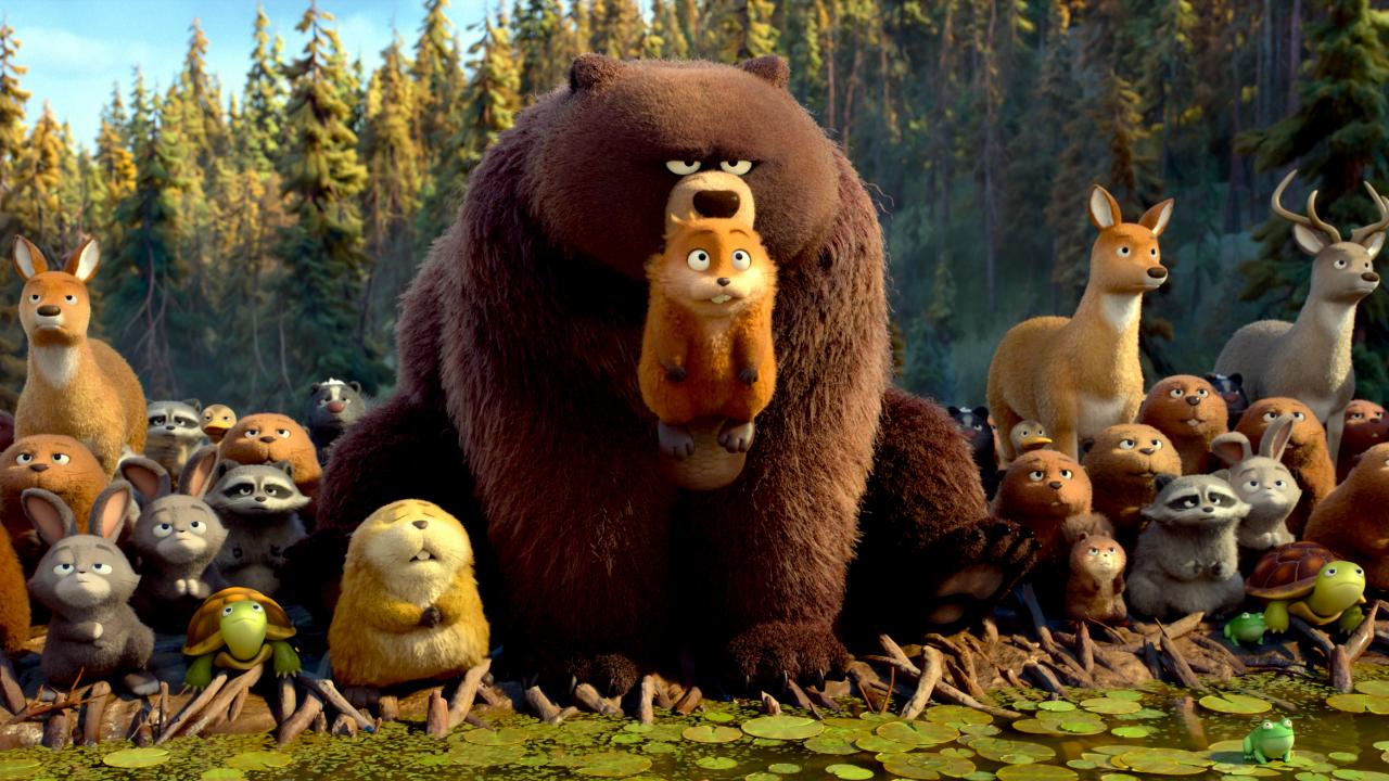 Still aus dem Animationsfilm HOPPERS: Vor einem Wald stehen verschiedene wilde Tiere, etwa Hasen, Biber, Rehe, Waschbären. Im Mittelpunkt der Gruppe steht ein riesiger Braunbär, der einen kleinen Biber im Maul trägt.