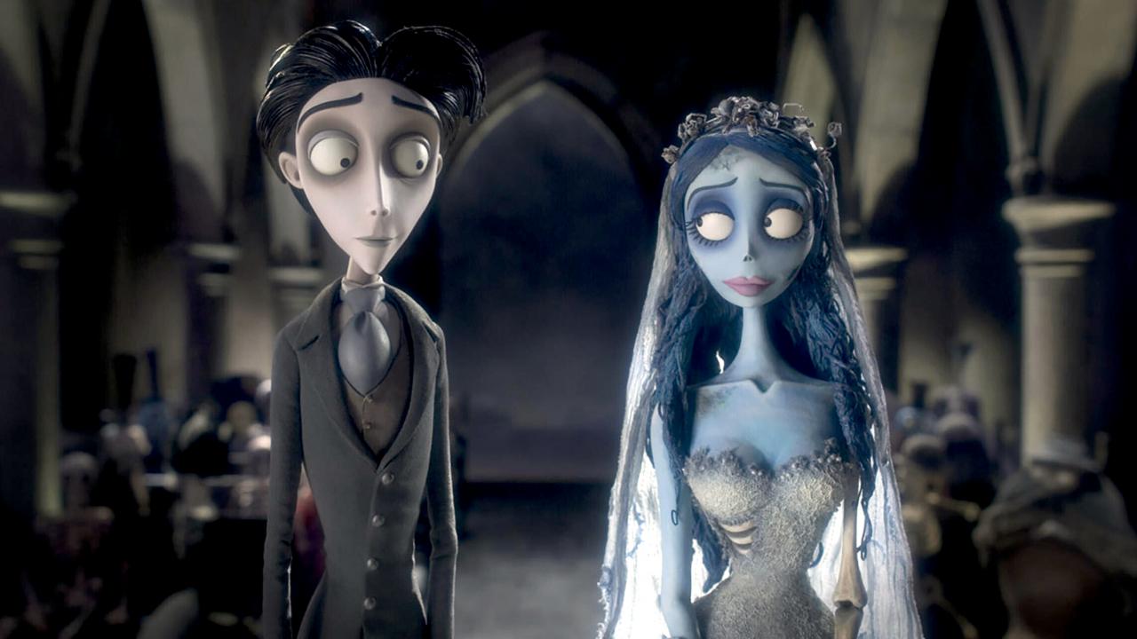 Still aus dem Puppentrickfilm Still aus CORPSE BRIDE – HOCHZEIT MIT EINER LEICHE: In einer Kirche stehen eine männliche und ein weibliche Figur nebeneinander. Sie schauen sich an. Die Braut hat – im Gegensatz zum Bräutigam – eine bläuliche Hautfärbung.
