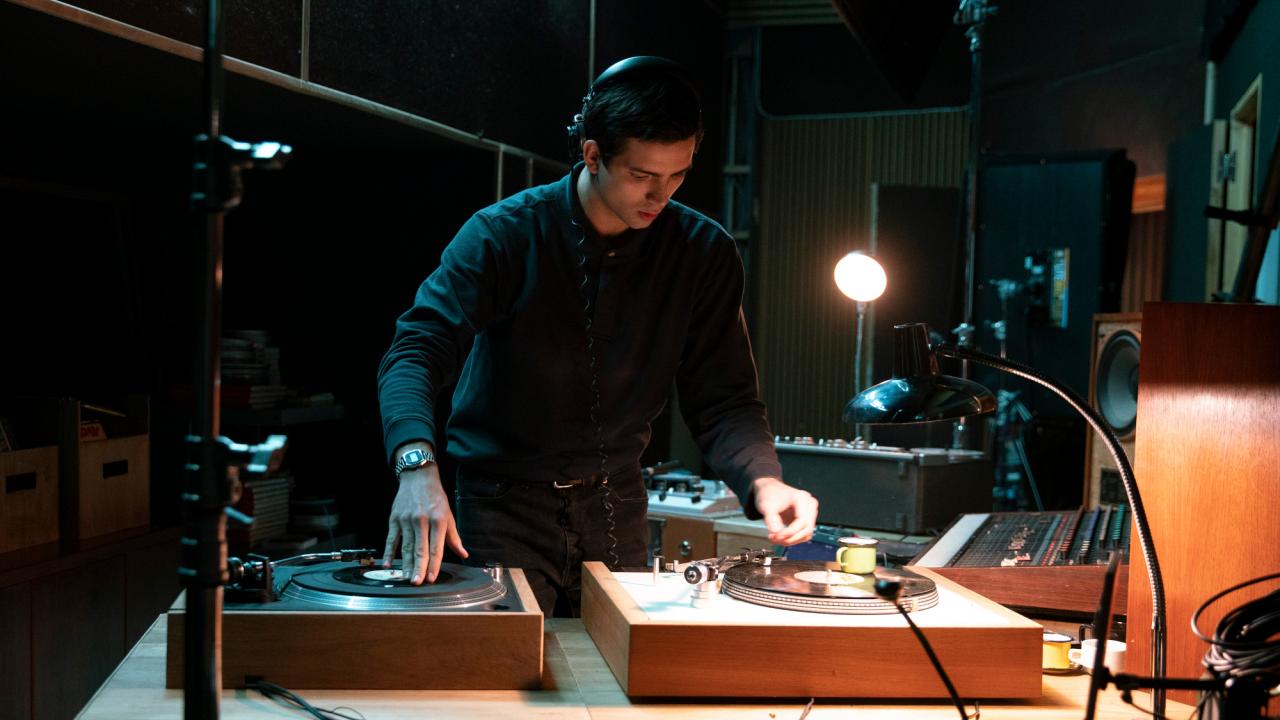 Filmstill aus dem Drama DIE MAGNETISCHEN: Ein junger Mann steht in einem Tonstudio an den Turntables.
