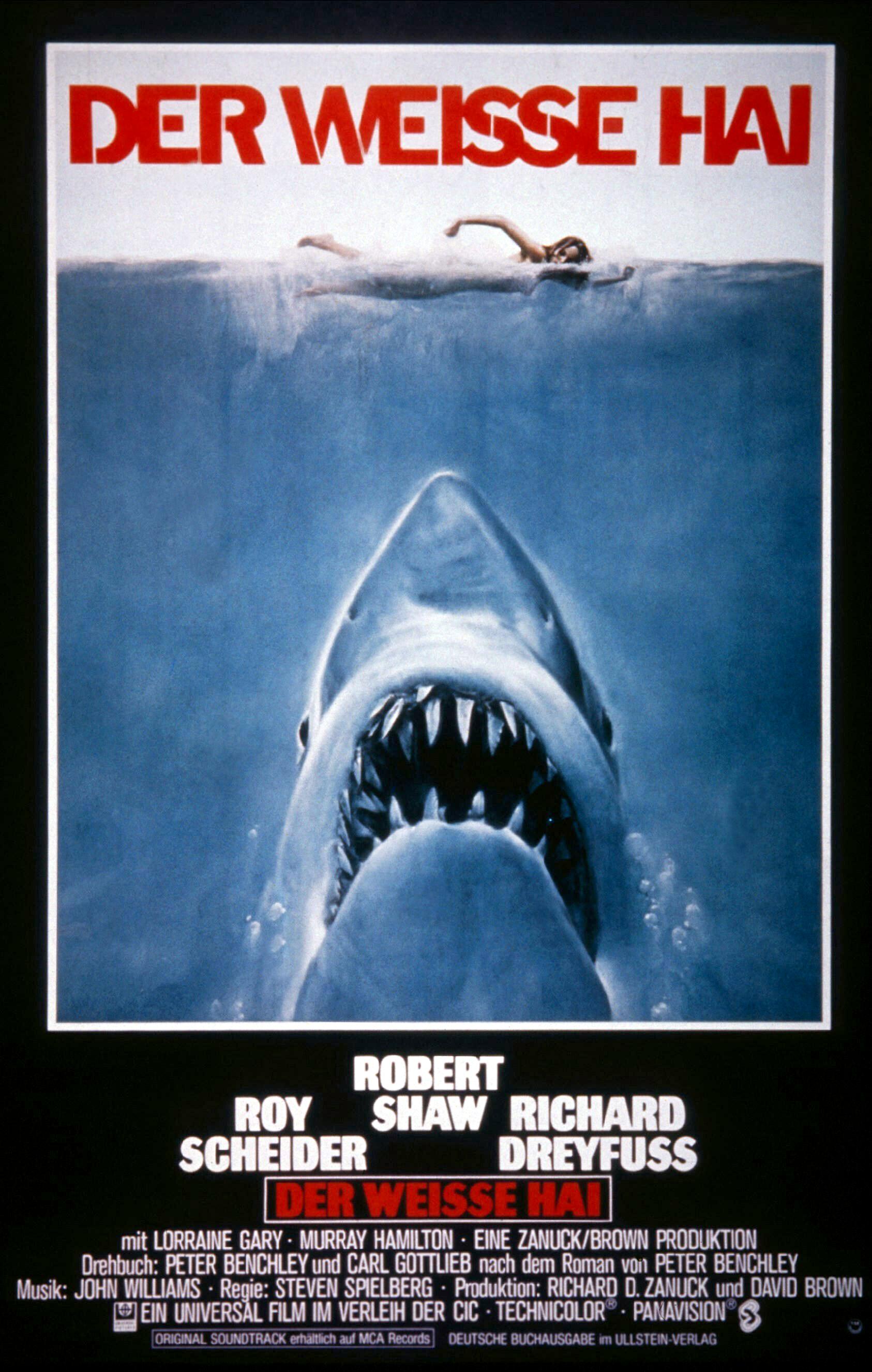 Filmplakat zu DER WEISE HAI: Eine Zeichnung: Eine Frau schwimmt im Meer. Direkt unter ihr ist frontal der riesige Kopf eines weißen Hais mit aufegrissen Maul zu sehen. Der Filmtitel steht in roten Buchstaben am oberen Bildrand.