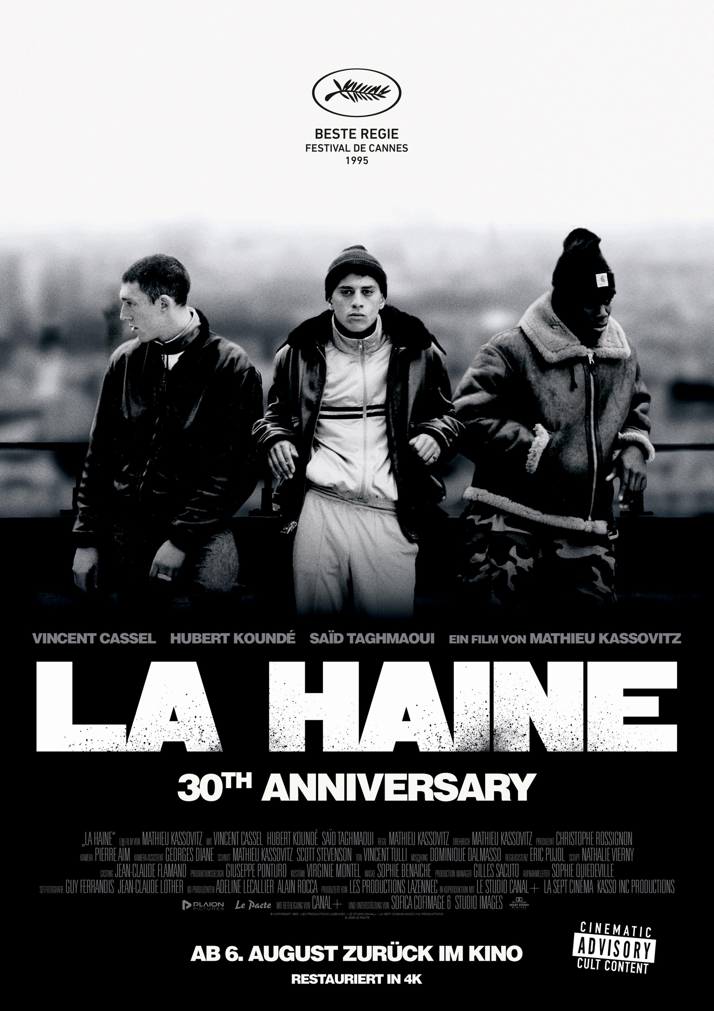 Filmplakat zum 30. Jübiläum von LA HAINE – HASS: Drei junge Männer stehen vor einem Stadtpanorma.