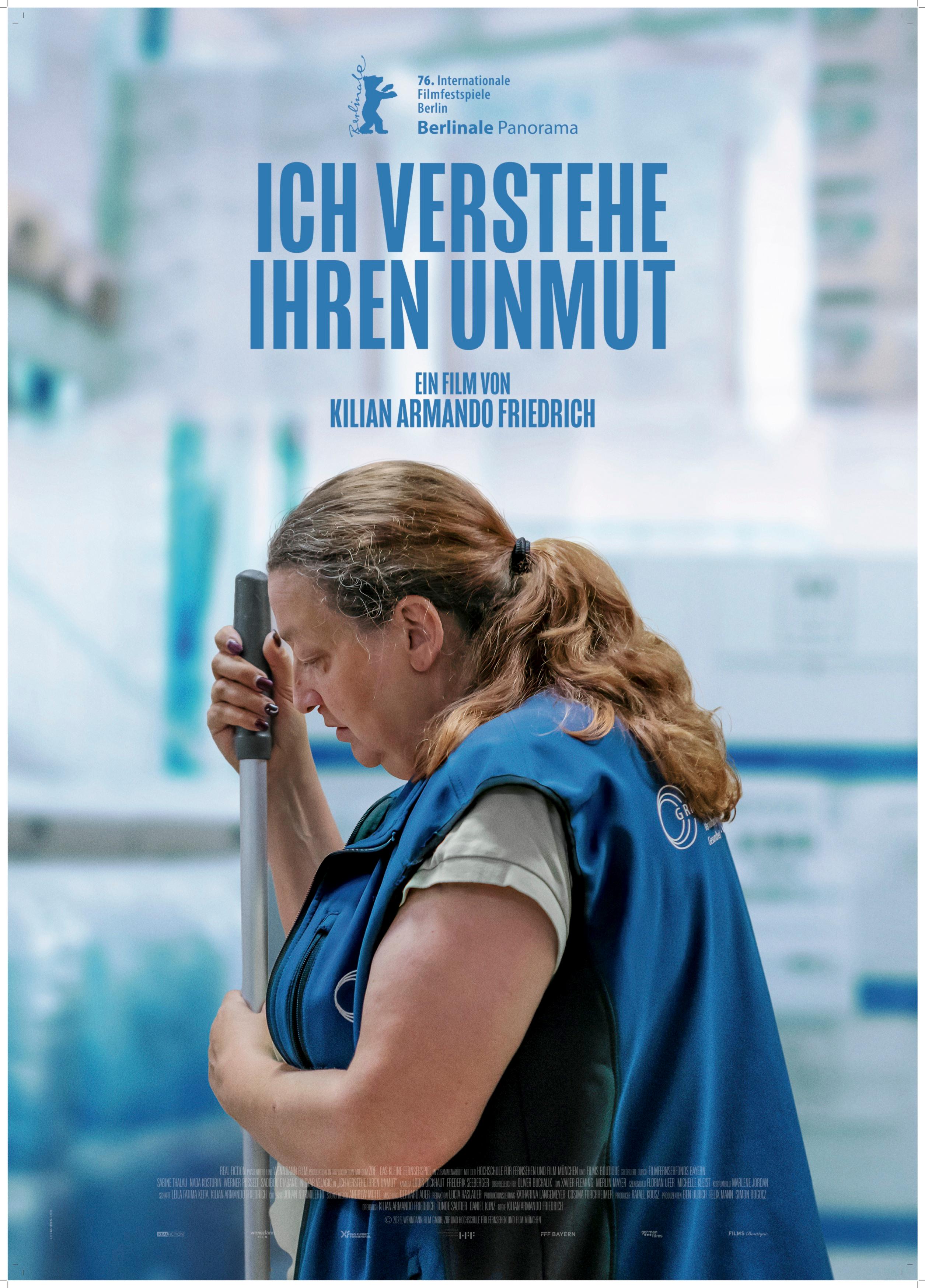 Plakat zum Drama ICH VERSTEHE IHREN UNMUT: In einer halbnahen Einstellung ist im Profil eine Frau Ende 50 abgebildet. Sie trägt einen blauen Kittel und hat den Stiel eines Besens oder Wischmopps in der Hand.  Das Bild ist bläulich gehalten. Der Filmtitel steht in blauen Buchstaben über der Frau.