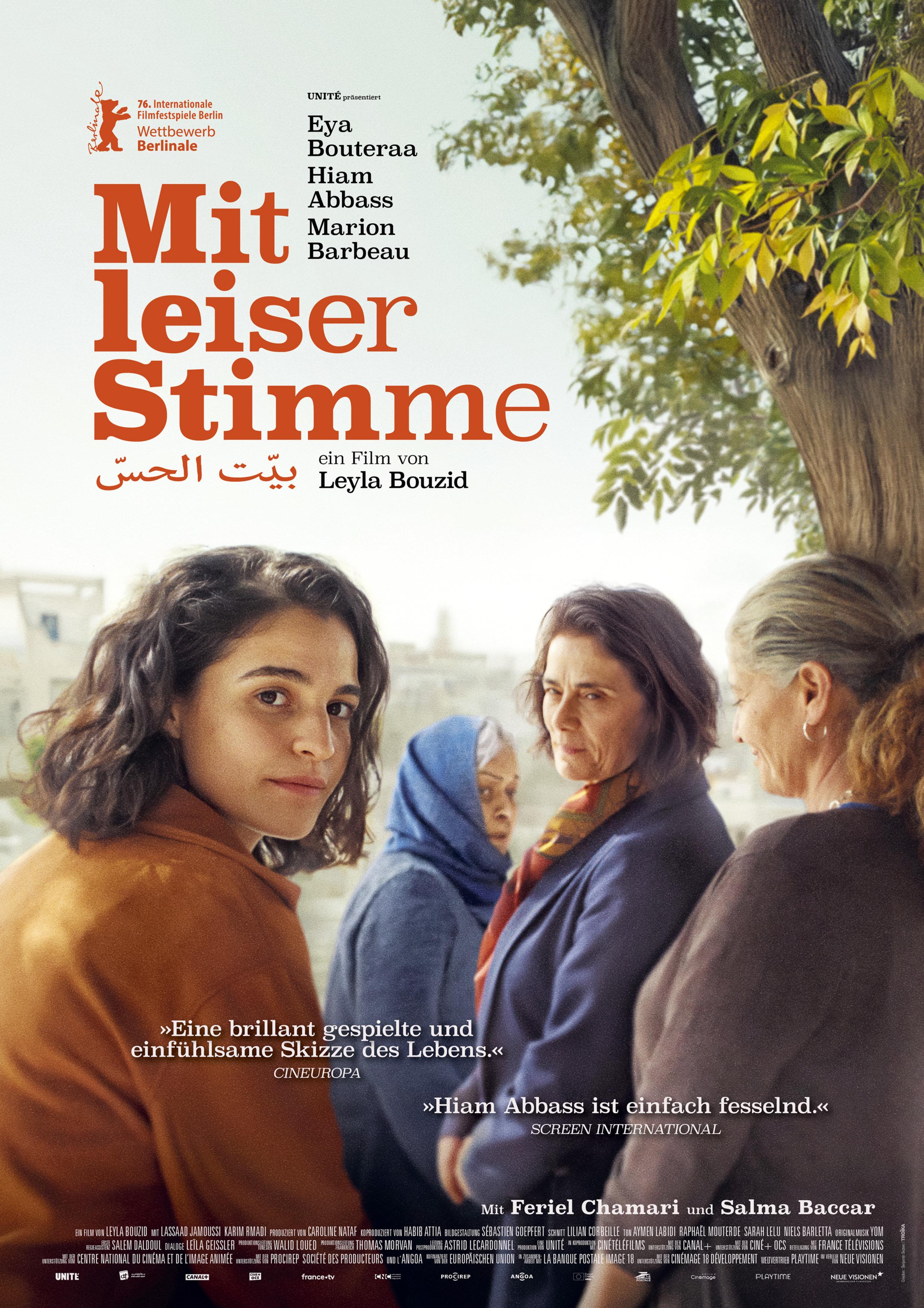 Filmplakat zum Drama MIT LEISER STIMME: Eine junge Frau blickt den Betrachter direkt an, während im Hintergrund drei Frauen unter einem Baum stehen; der Filmtitel ist in roter Schrift links platziert.