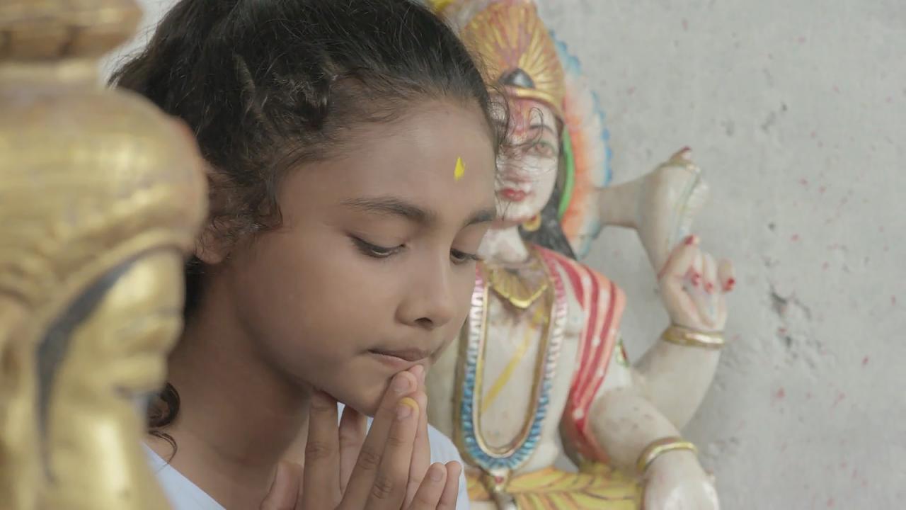 Sarita, Szenenbild: Ein junges betendes Mädchen vor einer Shiva-Figur