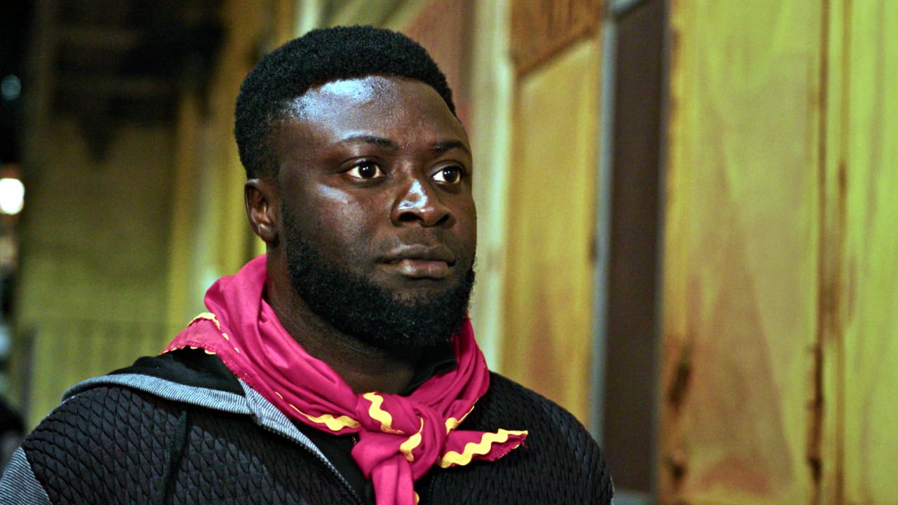 Still aus dem Dokumentarfilm A BLACK JESUS: Porträt des 19-jährigen Edward aus Ghana, der ein rotes Halstuch trägt