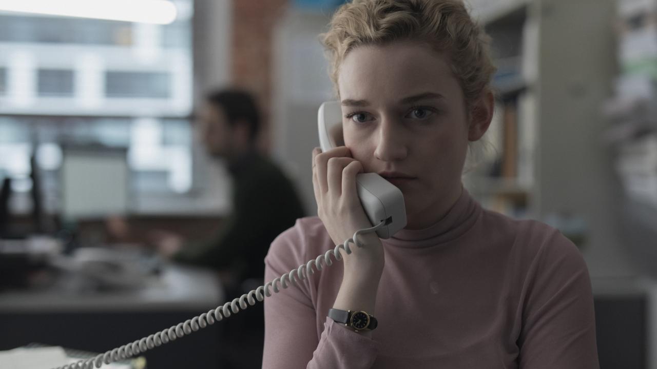 The Assistant, Szenenbild: Nahaufnahme einer jungen blonden Frau, die einen Telefonhörer an ihr Ohr hält.