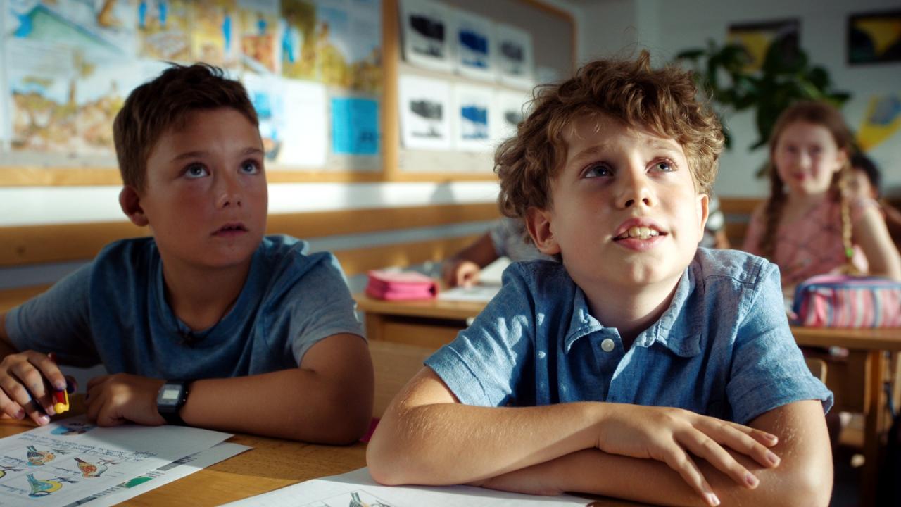 Filmstill aus dem Film GESCHICHTEN VOM FRANZ: Zwei Jungen sitzen in einem Klassenzimmer nebeneinander an einem Schultisch.