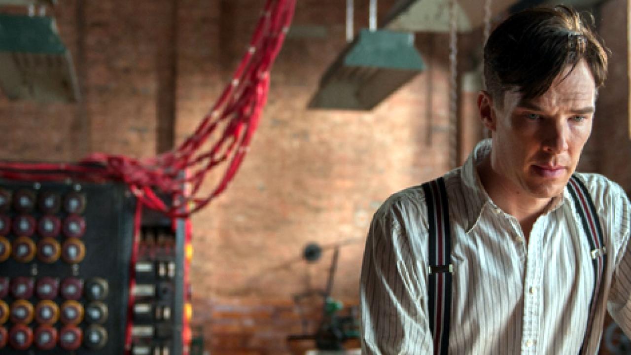 Still aus THE IMITATION GAME: Alan Turing (Benedict Cumberbatch) steht in einem Raum, im Hintergrund  ist eine Maschine mit Kabeln zu erkennen.
