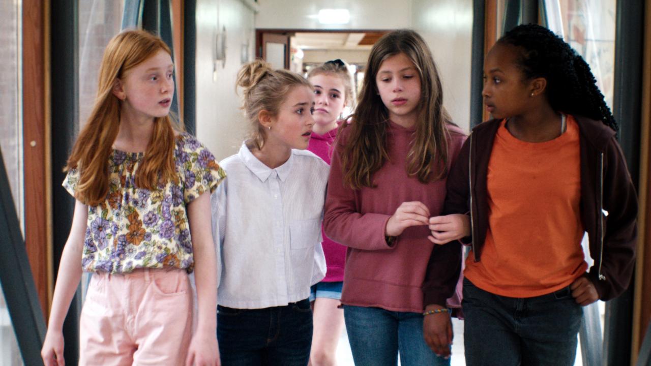 Still aus dem Film LARS IST LOL: Eine Gruppe von fünf Mädchen gehen einen Gang entlang.